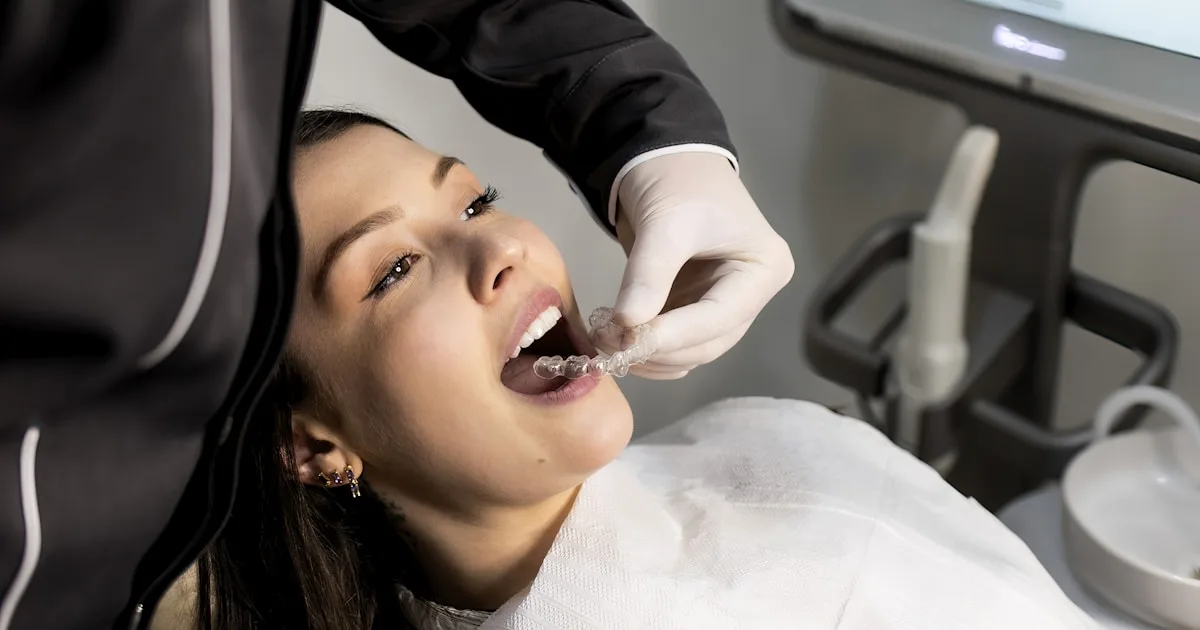 Dental patient with a 3D digital model of her teeth displayed on the monitor behind her — digital smile design in Royal Palm Beach FL