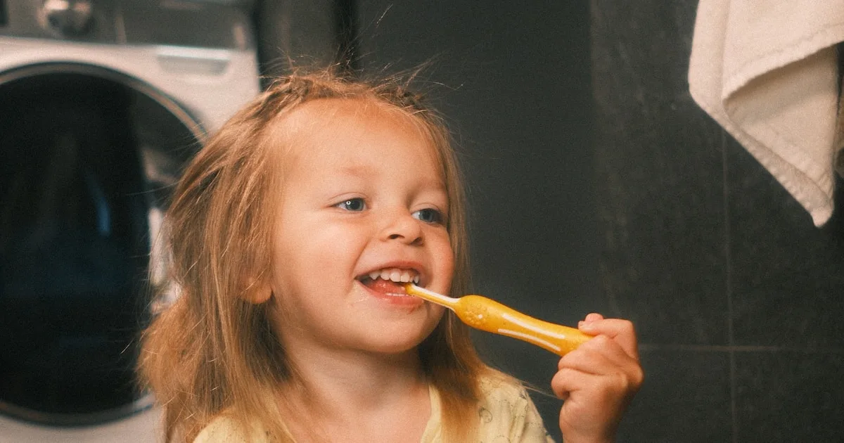 Young child brushing her teeth with fluoride toothpaste — cavity prevention in Royal Palm Beach and Wellington FL